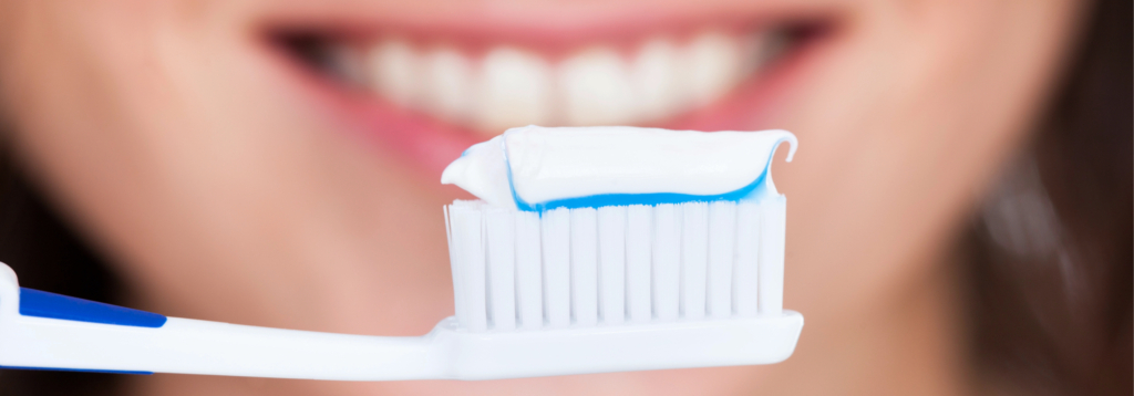 Gros plan sur une brosse à dents avec du dentifrice, mettant en avant l'importance d'une bonne hygiène buccale pour prévenir le saignement des gencives.