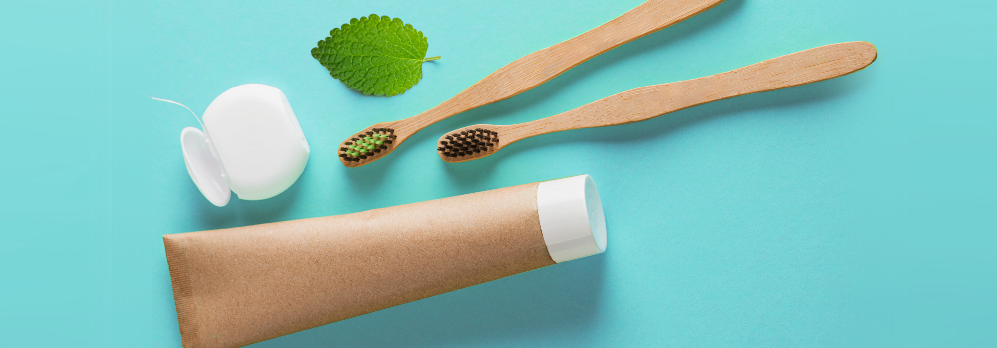 Dentifrice naturel en emballage écologique, brosses à dents en bambou, soie dentaire et feuille de menthe